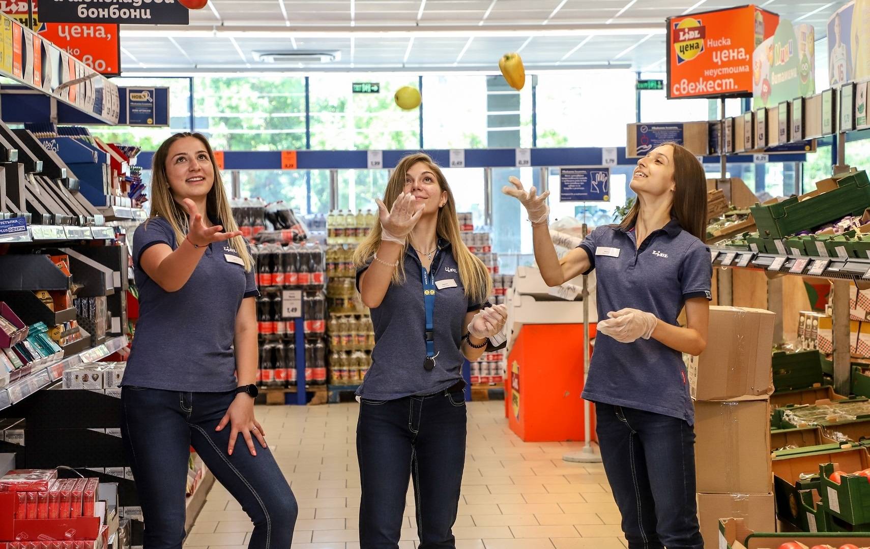 Три момичета- практиканти жнглират с плодове в магазин н Lidl