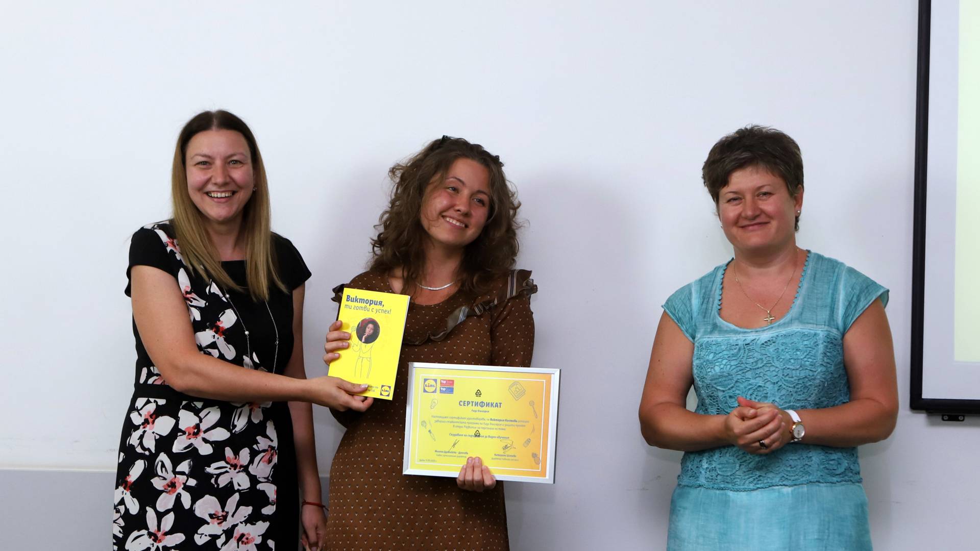 Виктория Костова получава сертификат от главен изпълнителен директор Милена Драгийска и директор човешки ресурси Катерина Шопова