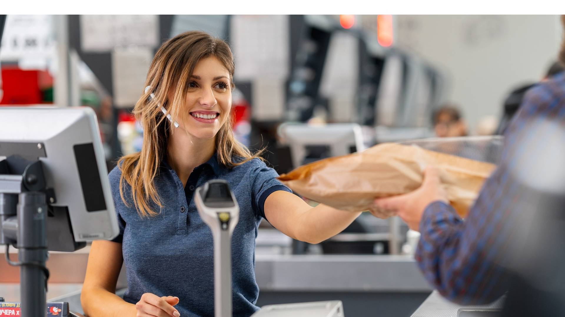 Жена касиер продавач подава хляб на клиент на каса