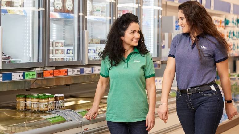 Две колежки, усмихнати до витрините със сладолед в магазин на Lidl