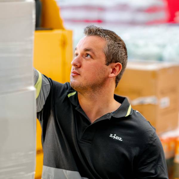 Мъж складов работник проверява стока в централен склад